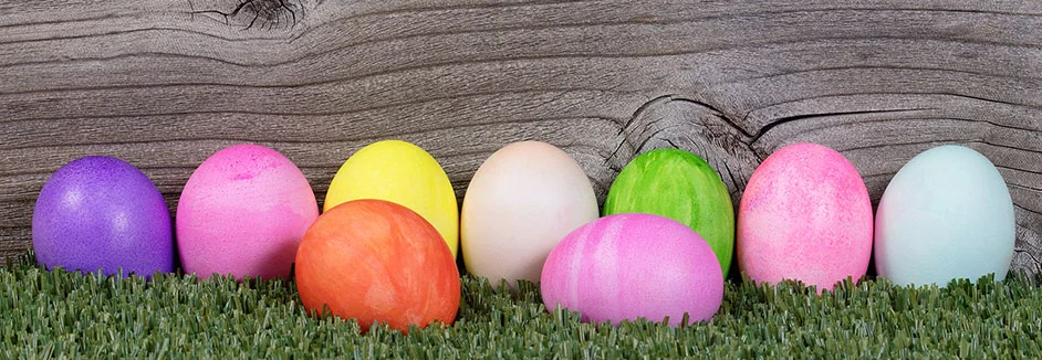 Neun bunte Ostereier im Gras